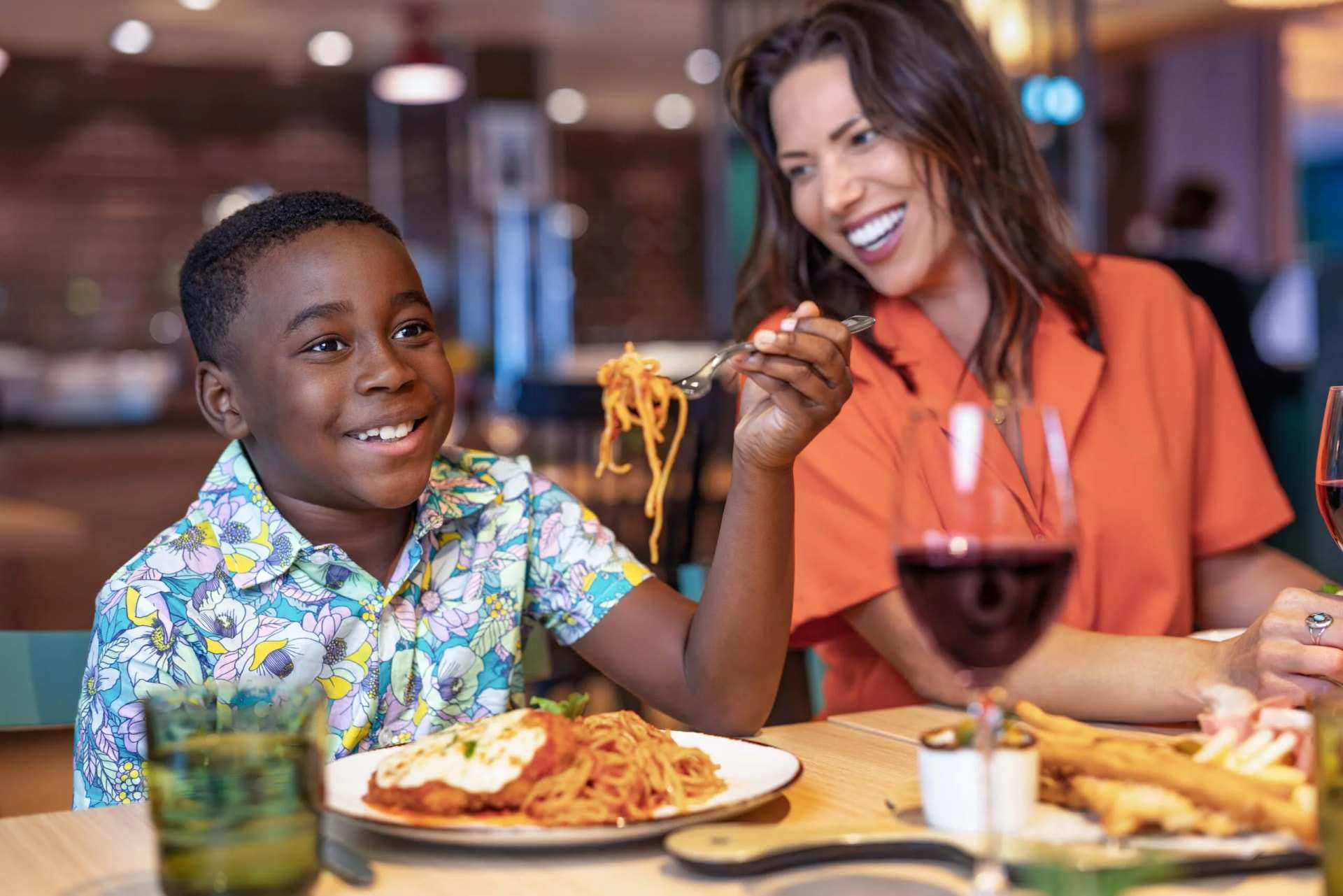 A child and a woman eating pasta in a ship's restaurant