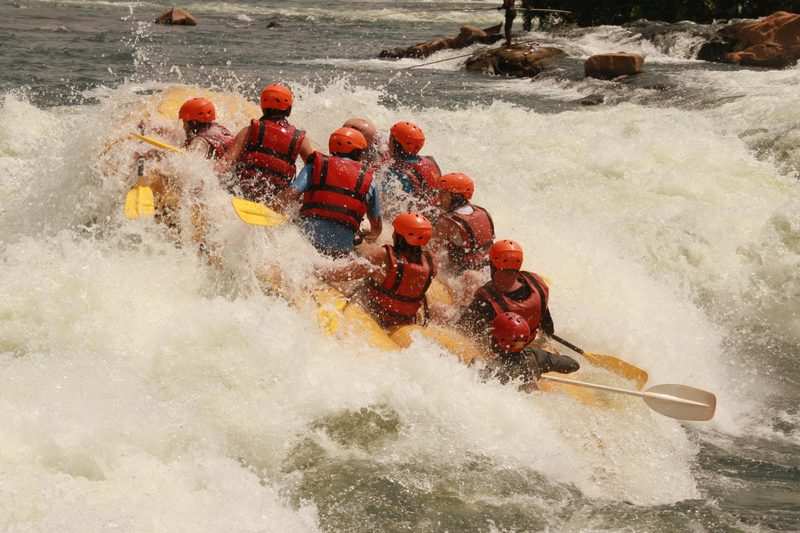 A raft crew paddling hard through a wall of white water on the Nile at Jinja